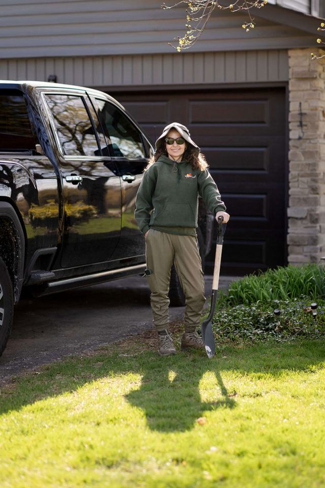 Maria from Maple Leaf Lawn Maintenance in Kitchener standing with a shovel in a front yard