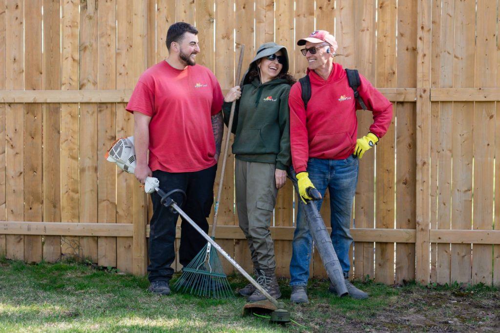 Lawn care team in Kitchener standing with tools including rake, blower, and trimmer