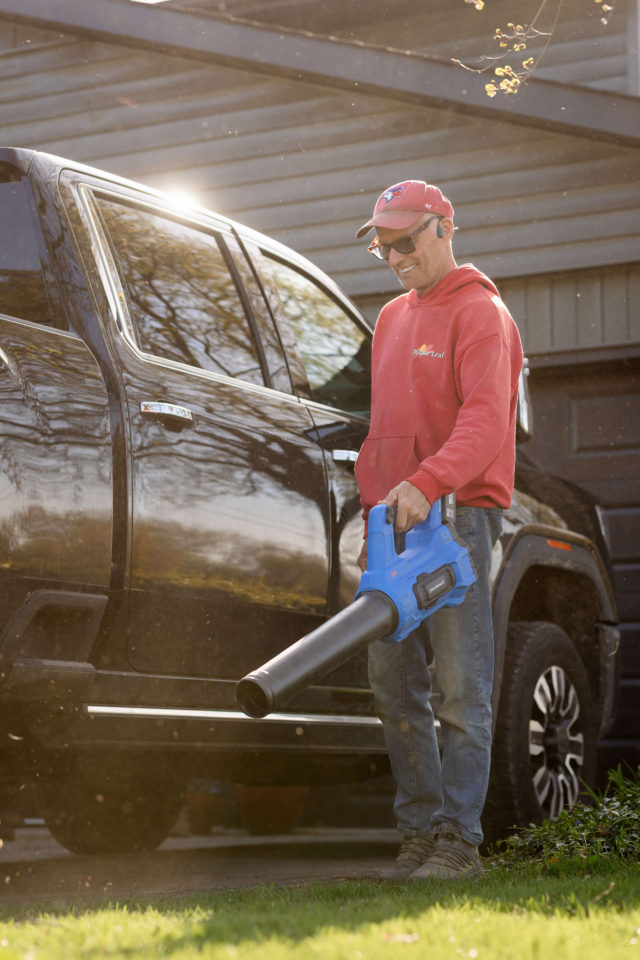 Mark at Maple Leaf Lawn Maintenance using a leaf blower at a residential property in Kitchener